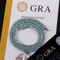 Shiny moissanite tennis bracelet with green and blue diamonds on GRA report background, highlighting elegance and quality.